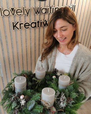 Gl&uuml;ckliche Teilnehmerin des Adventskranz Workshops im KreativWerk Pattensen. Wundersch&ouml;ner selbst gefertigter Adventskranz aus verschiedenem Tannengr&uuml;n und rustikalen Stumpenkerzen in taube.