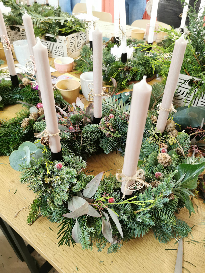 Handgefertigter Adventskranz aus Tannengrün, Eukalyptus, Zapfen und Beeren im KreativWerk Pattensen. Mit extra langen stabserzen in der Farbe taube